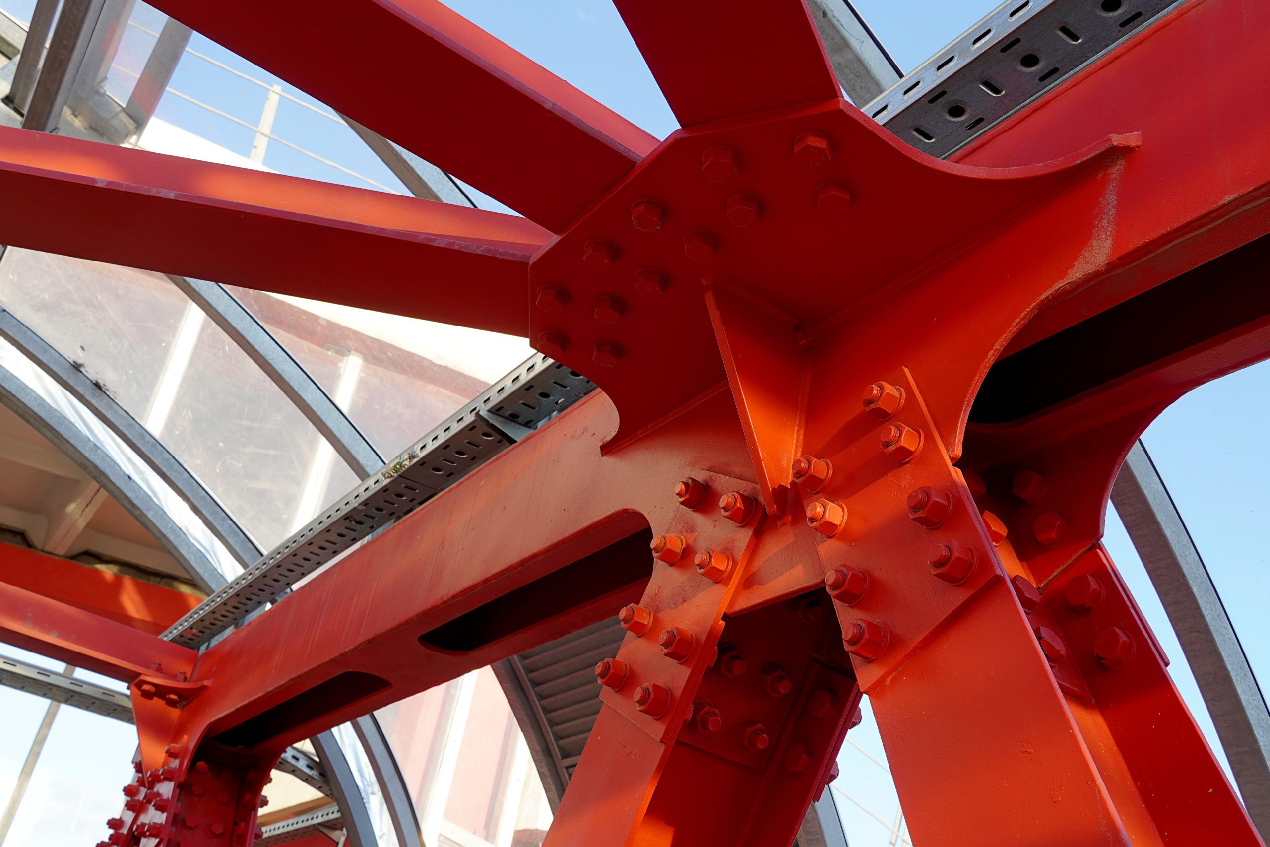 Red iron beams bolted on. Angular connection of several iron beams in one place close up.