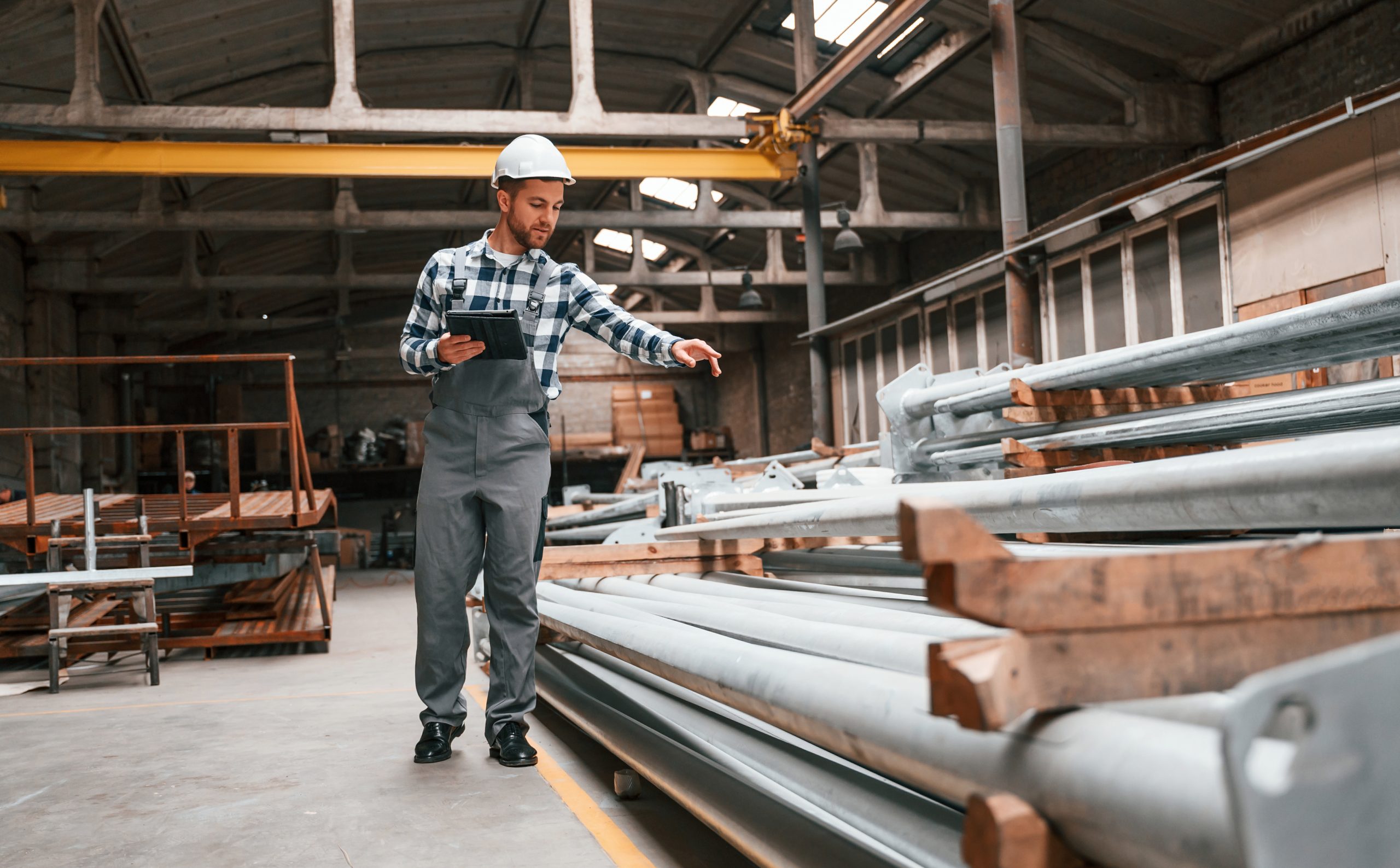 Quality control. Factory male worker in uniform is indoors